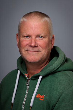 en skallet person iført en grønn jakke